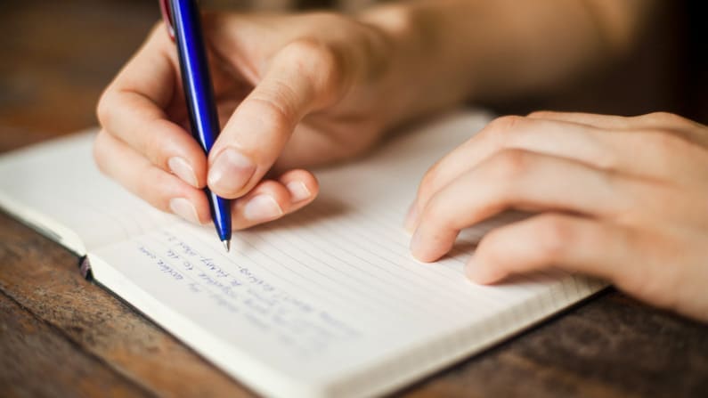 a woman writing in her garden journal in March