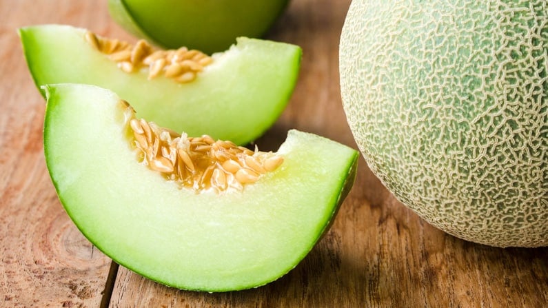 cut honeydew sitting on a wood counter